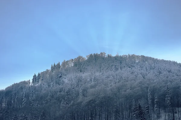 冬の間に山の背後にある太陽光線 — ストック写真