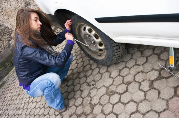 Young woman during the wheel changing — Stock Photo, Image