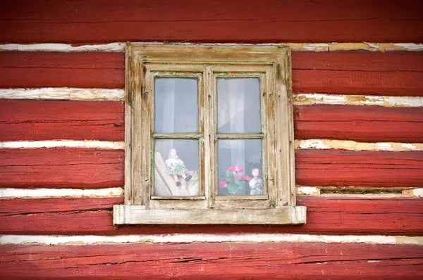 Altes Holzfenster in der Hüttenwand mit ein paar Puppen drinnen — Stockfoto