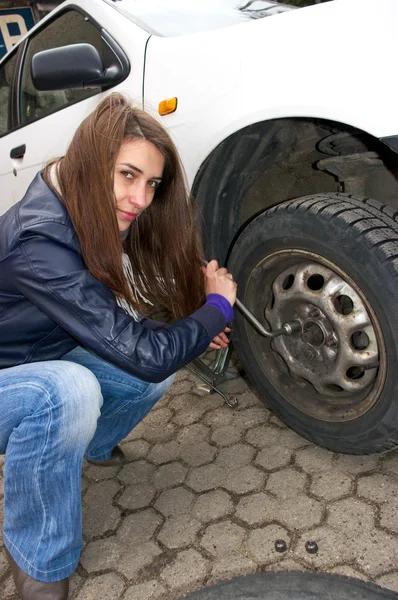 Молодая женщина во время смены колеса — стоковое фото