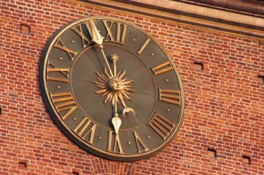 Golden clock in red wall of city hall tower in Krakow, Poland clipart