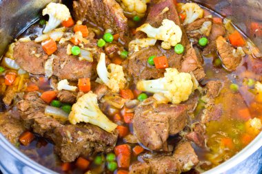 Fricassee with cauliflower, green peas and carrots clipart