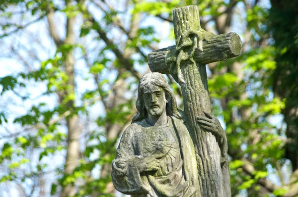 Very old stone Christ statue on tomb in graveyard — Stock Photo, Image