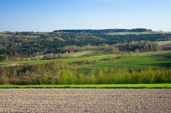 Landskap med plöjde fältet på första plan — Stockfoto
