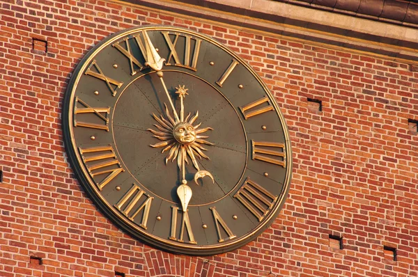 Orologio d'oro nel muro rosso della torre del municipio di Cracovia, Polonia — Foto Stock