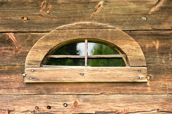 Oude vreemd venster in houten muur — Stockfoto