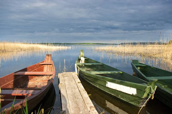 Scena con due barche, lago e molo — Foto Stock