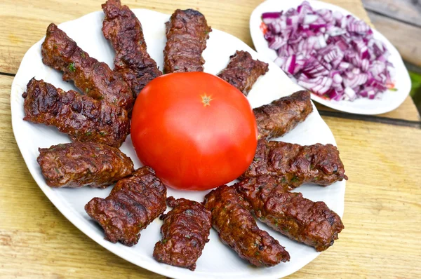 Cevapcici tradicional croata con cebolla roja y tomate —  Fotos de Stock