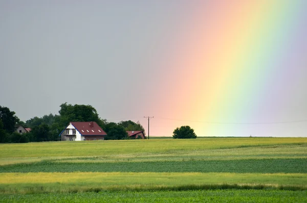 Mooie regenboog over het dorp — Stockfoto