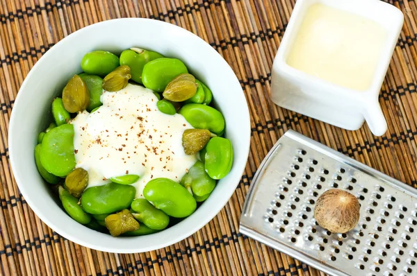 Broad beans and capers with creamy nutmeg sauce — Stock Photo, Image