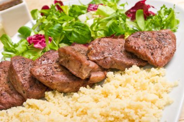 Tenderloin steaks in wine sauce with cadamon and kuskus groats clipart