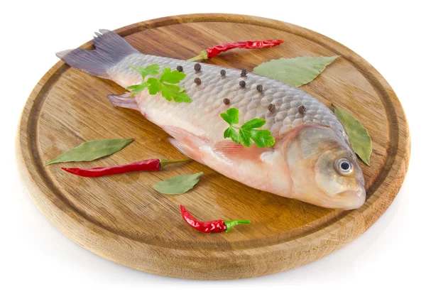 Fish on wooden board with spice — Stock Photo, Image