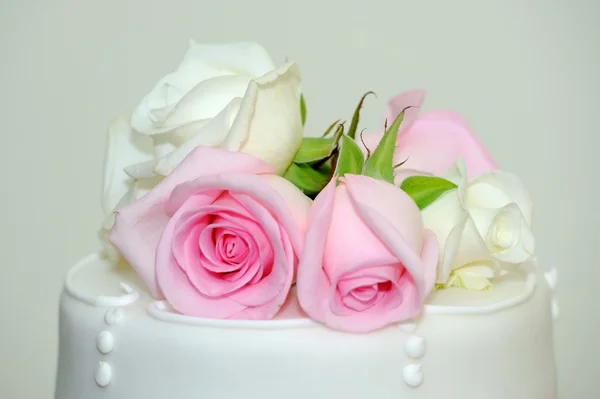 Rosa rosor på bröllopstårta. — Stockfoto
