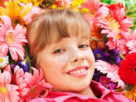 Enfant couché sur des fleurs .