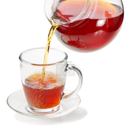 Thé versé dans une tasse de thé isolé sur un fond blanc 