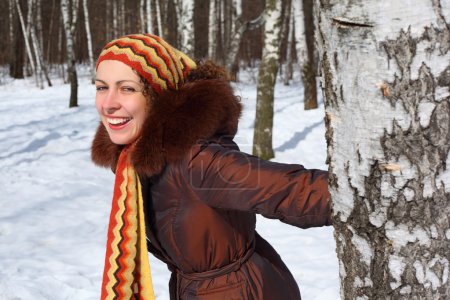 Jeune belle femme en bois garde pour le bouleau en hiver 