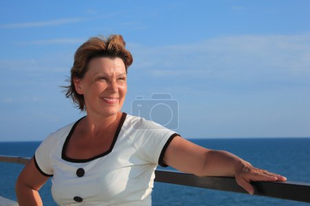 portrait de femme d'âge moyen sur le balcon sur la mer 