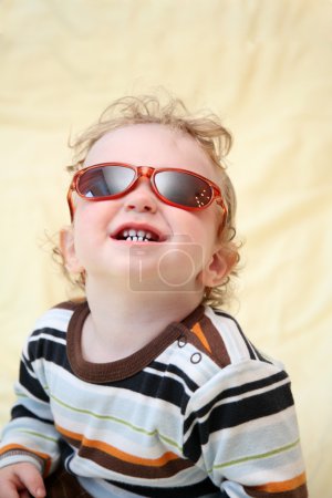 enfant dans les lunettes de soleil regarde vers le haut 