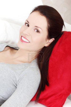 Belle femme souriante allongée sur un canapé .