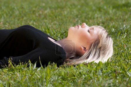 Jeune femme couchée sur une prairie 
