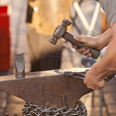 marteau, enclume et les mains d'un forgeron 