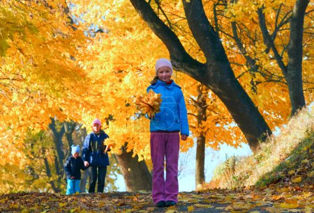 Famille dans le parc d'érable d'automne 