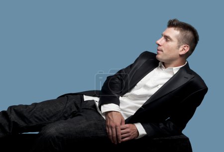 Jeune homme en costume couché 