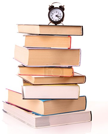 Livres à couverture rigide et réveil isolés sur blanc 
