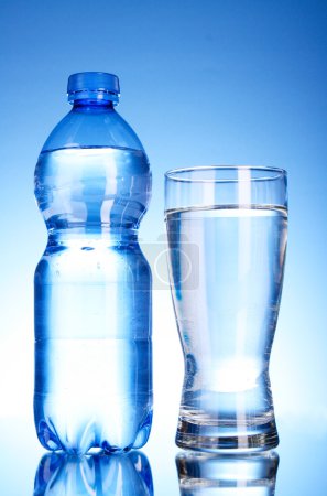 Bouteille d'eau et de verre sur fond bleu 