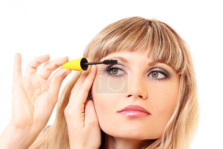 Maquillage jeune femme avec mascara isolé sur blanc 