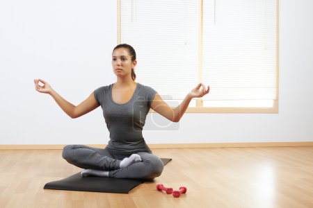 Femme faisant du yoga à la maison