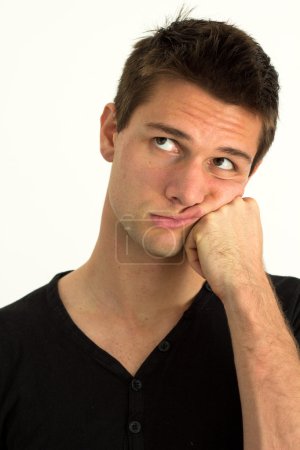 Jeune homme inquiet avec la main sur le visage 
