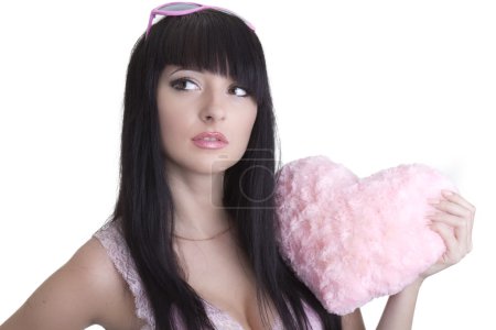 Belle femme dans des lunettes roses avec coeur en peluche 