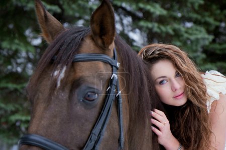 Fille dans une robe blanche sur un cheval 